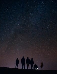 silhouette of five persons staring at the stars at nigh