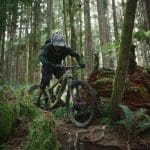 man in black jacket riding black mountain bike in forest during daytime