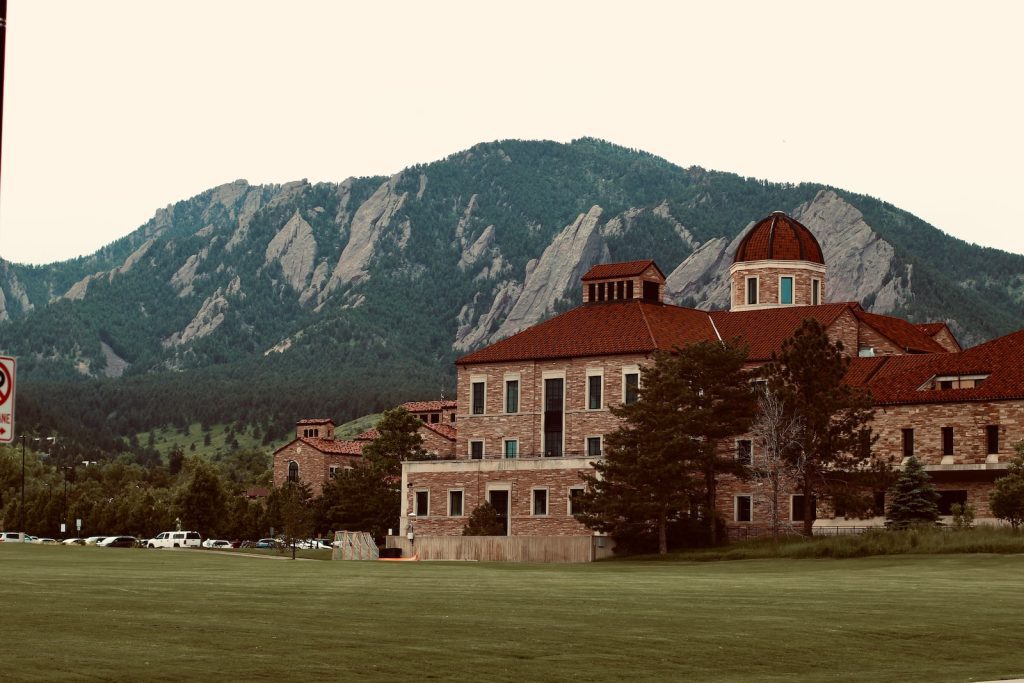 a large building in front of a mountain range
