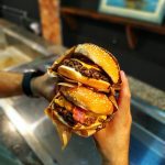 Person Holding Two Burgers