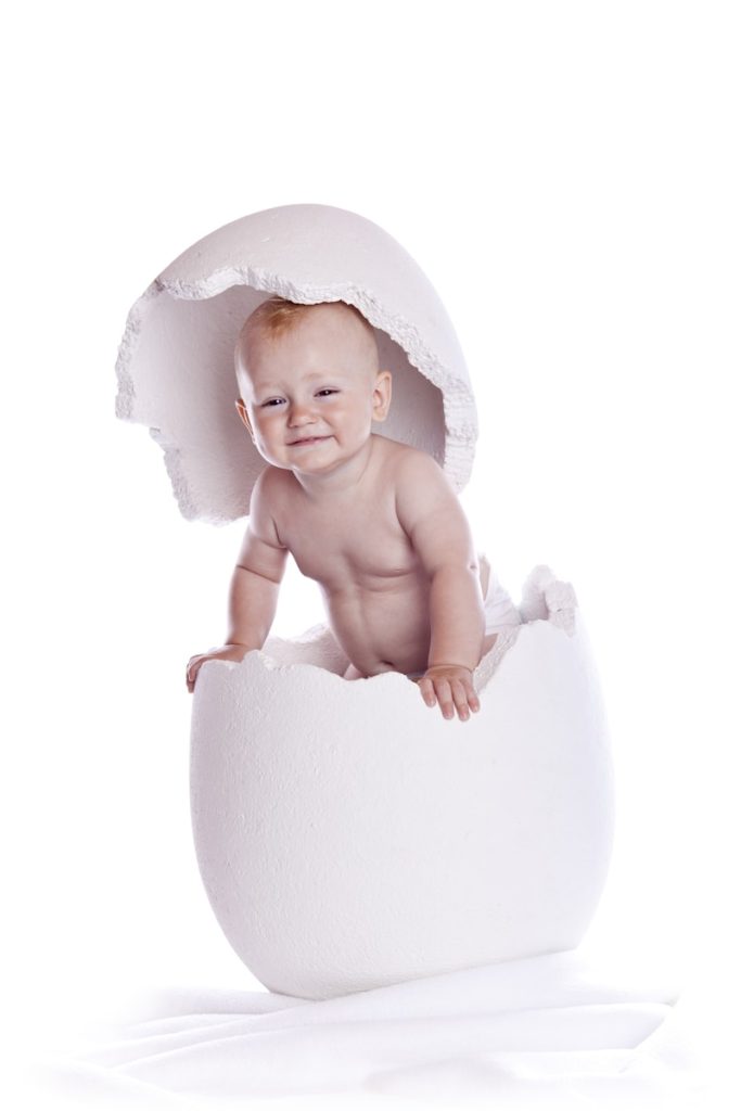 a baby sitting inside of an egg shell